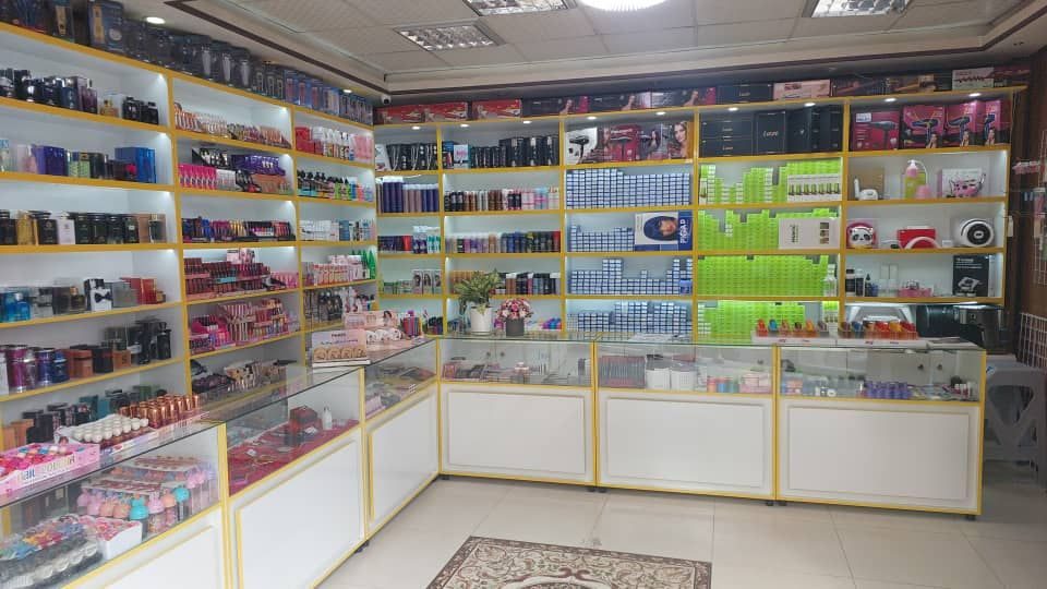 دکور فروشگاه آرایشی — قفسه لبهطلایی و ویترین